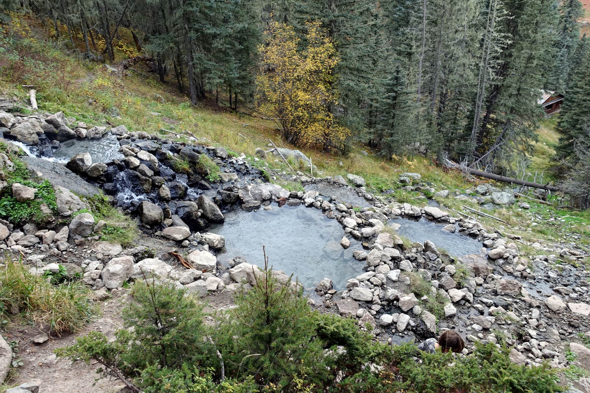Rock-lined primitive soaking pools of San Antonio Hot Springs on a forested hillside in the Jemez Mountains