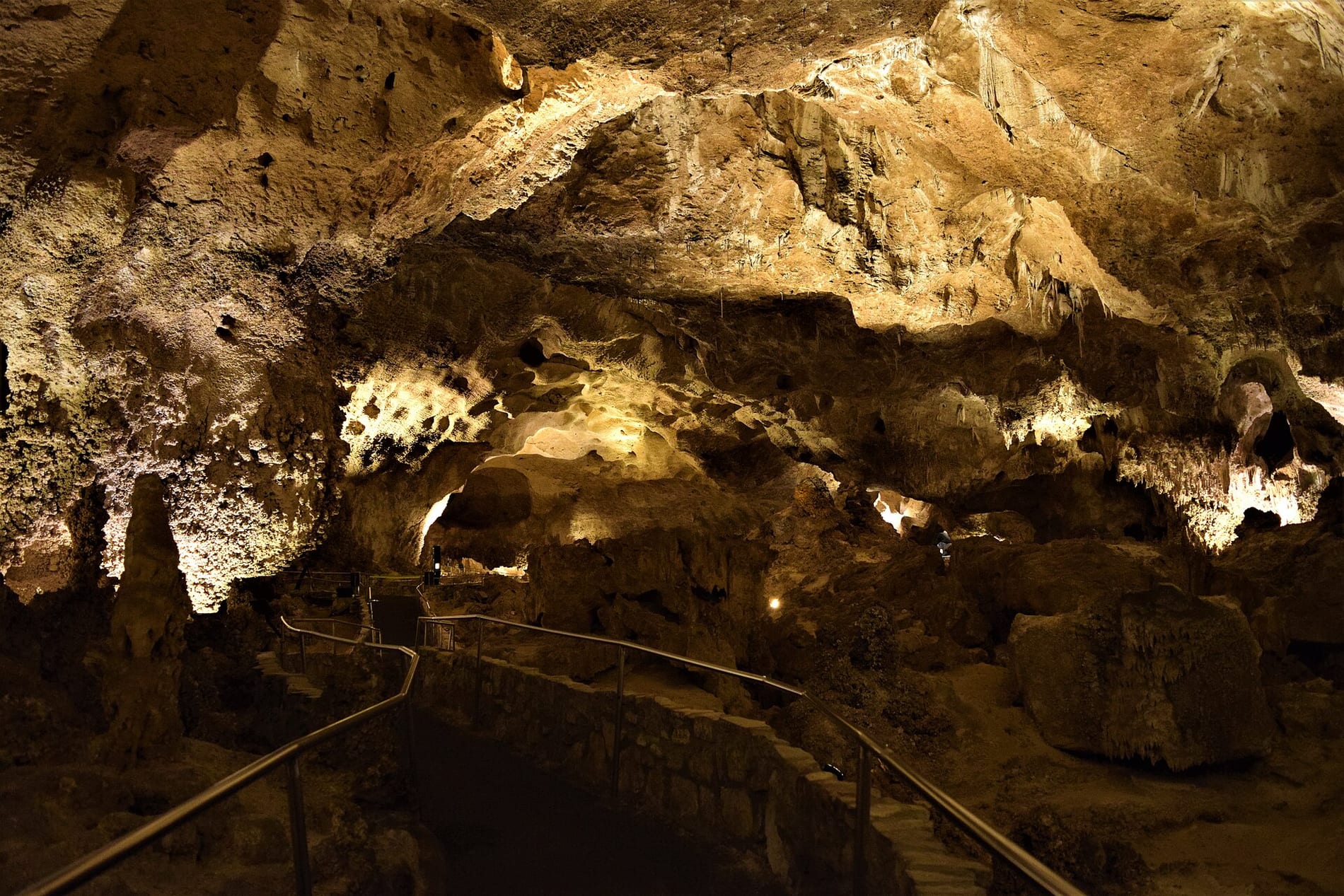 Lit limestone formations along the paved trail in the Big Room at Carlsbad Caverns